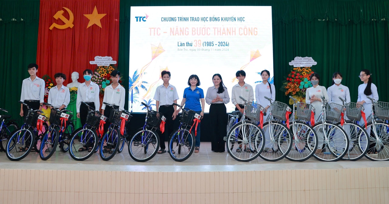 A group of people standing on a stage with bicycles  Description automatically generated