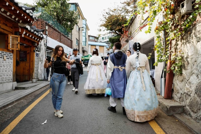 Khách du lịch đi dạo, check in ở làng Bukchon Hanok. Ảnh: Reuters