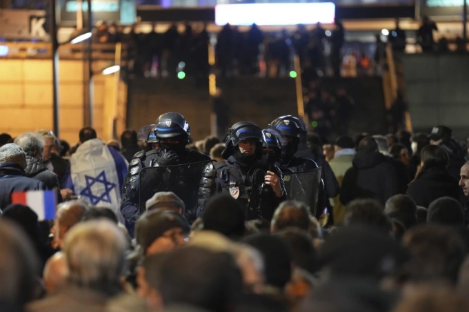 Các cảnh sát theo dõi người hâm mộ trước trận Pháp gặp Israel bên ngoài sân vận động Stade de France, Paris hôm 14/11. Ảnh: AP