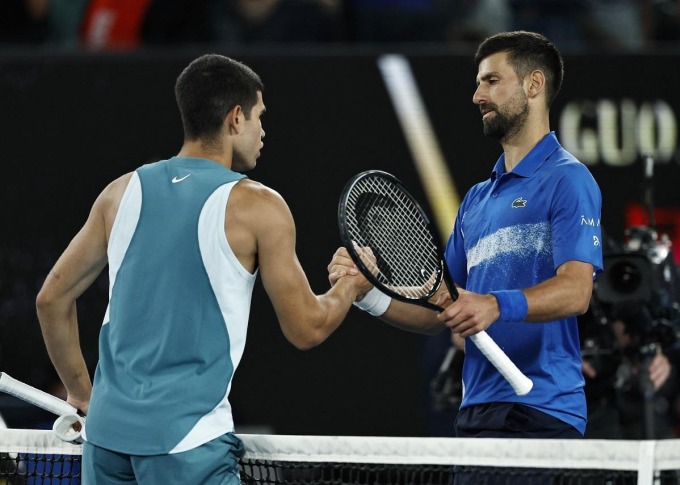 Djokovic (phải) bắt tay Alcaraz, sau trận tứ kết Australia Mở rộng trên sân Rod Laver, Melbourne hôm 21/1. Ảnh: Reuters