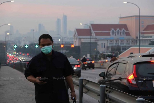 A pedestrian wearing a face mask uses the Phra Pinklao Bridge to cross the Chao Phraya River in Bangkok amid thick smog Thursday morning. (Photo: Jetjaras Na Ranong)  Please credit and share this article with others using this link: https://www.bangkokpost.com/thailand/general/2945695/most-of-thailand-still-faces-red-levels-of-smog. View our policies at http://goo.gl/9HgTd and http://goo.gl/ou6Ip. © Bangkok Post PCL. All rights reserved.