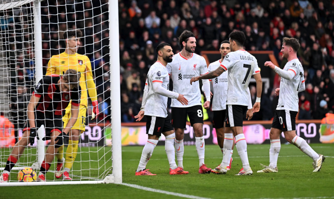 Các cầu thủ Liverpool ăn mừng bàn phạt đền của Salah, trong khi hậu vệ Bournemouth nhanh chóng đưa bóng trở lại cuộc chơi. Ảnh: LFC