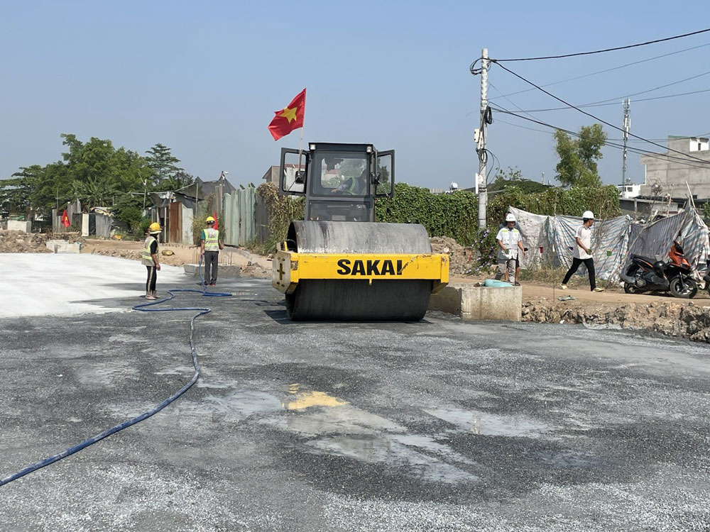 Công nhân rải đá, lu lèn chuẩn bị phần đường cho dự án cải tạo kênh Tham Lương - Bến Cát - rạch Nước Lên