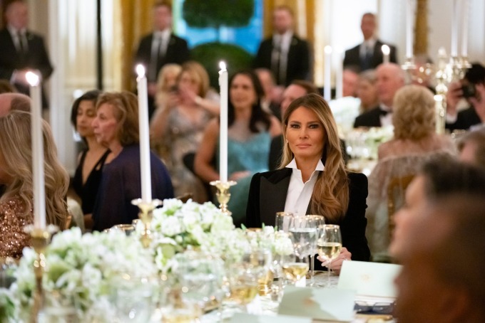 Bà Melania ngồi bên bàn tiệc trang trí bằng hoa cẩm tú cầu và tulip trắng. Ảnh: X/Flotus