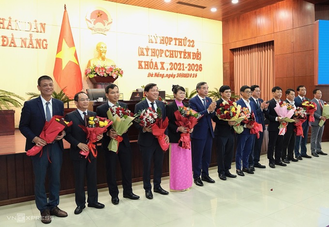 Ông Lê Trung Chinh (đứng giữa) tặng hoa chúc mừng sáu Uỷ viên UBND thành phố vừa được bầu và những người được miễn nhiệm khi nhận nhiệm vụ mới hoặc nghỉ hưu trước tuổi. Ảnh: Nguyễn Đông