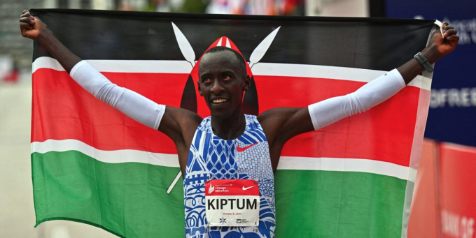 Kelvin Kiptum giương cờ Kenya sau khi phá kỷ lục marathon thế giới tại Chicago vào tháng 10/2023. Ảnh: Reuters