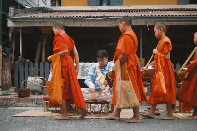 Lý Thành Cơ cúng dường cho các nhà sư khất thực tại Luang Prabang. Ảnh: NVCC