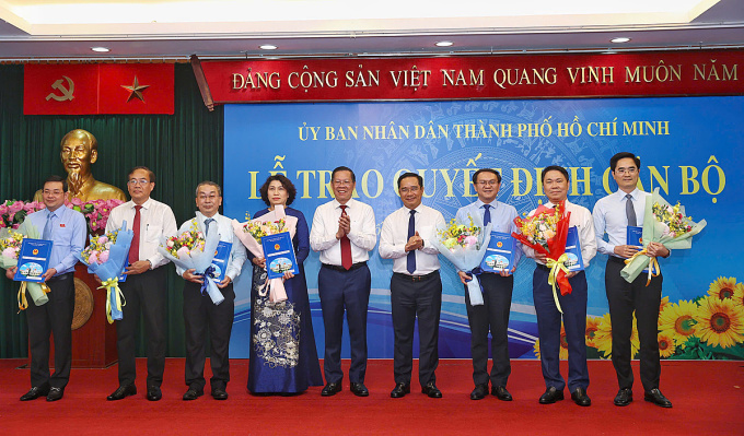 Ông Phan Văn Mãi, Chủ nhiệm Uỷ ban Kinh tế và Tài chính và ông Nguyễn Văn Được, Phó bí thư Thành ủy TP HCM trao quyết định và hoa cho 7 Giám đốc Sở mới. Ảnh: Quỳnh Trần