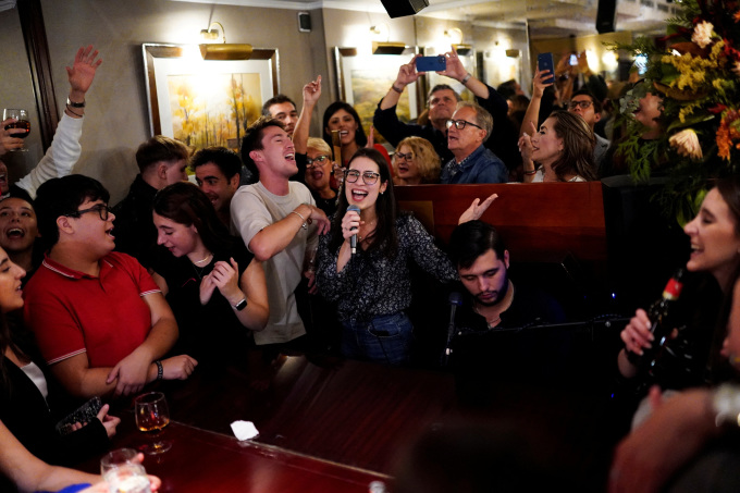 Mọi người hát theo người chơi đàn piano tại một quán bar ở Madrid, Tây Ban Nha, ngày 29/9/2024. Ảnh: Reuters