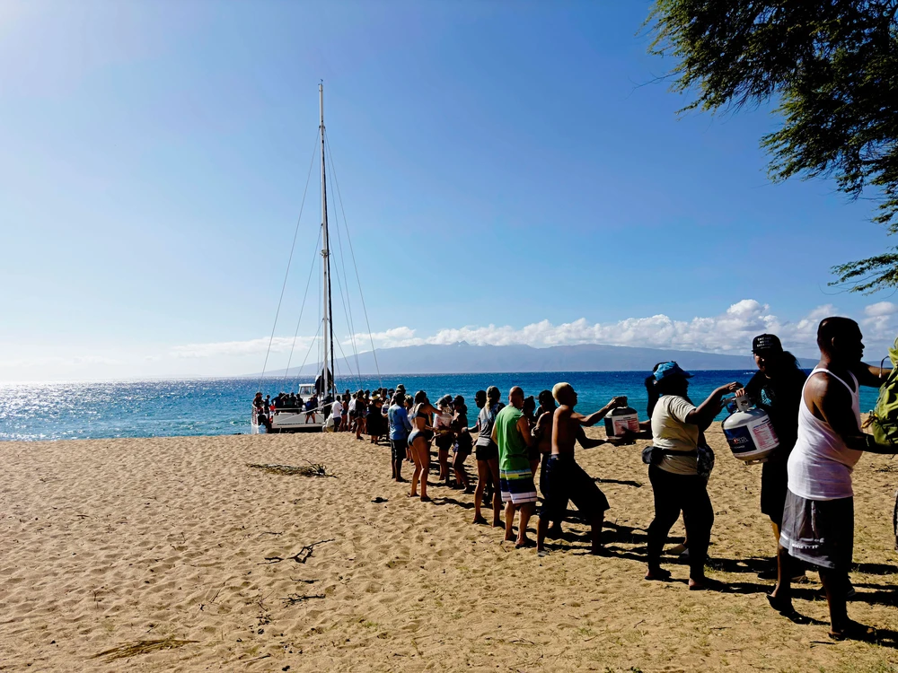 Người dân giúp chuyển hàng tiếp tế vào thị trấn Lahaina, đảo Maui (Hawaii, Mỹ) hôm 11-8. Ảnh: CNN