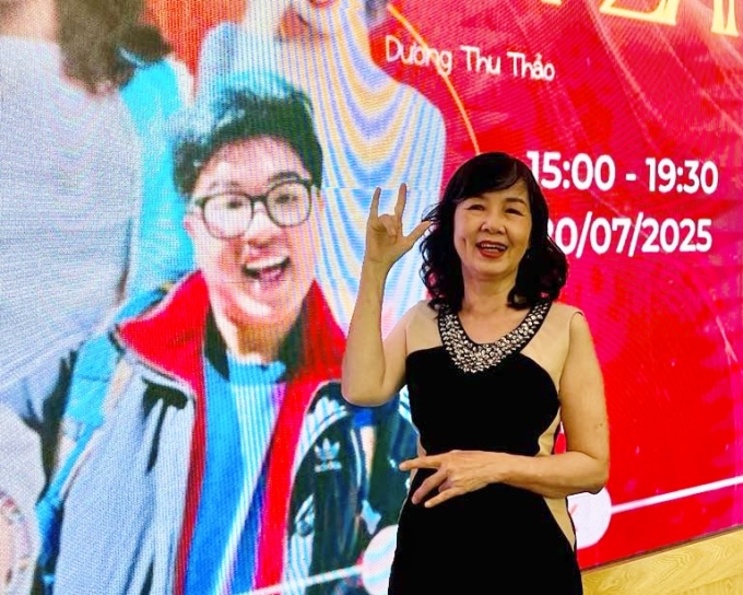 Mẹ của Đức Thiện ra dấu Mẹ yêu con bằng ngôn ngữ ký hiệu khi tham dự một sự kiện có con trai từ xa. Ảnh: Nhân vật cung cấp