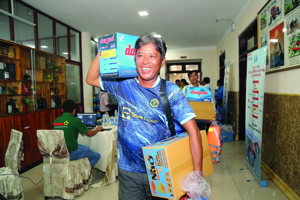 Ngư dân vui mừng nhận quà từ Chương trình “Cùng ngư dân thắp sáng đèn trên biển” đến với tỉnh Bạc Liêu vào ngày 29-9-2023. Ảnh: HOÀNG GIANG P2021_Cot phai_h6.jpg