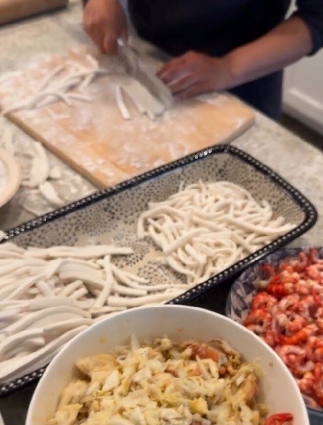 Nữ diễn viên tự tay cắt bột thành sợi bánh canh, từng sợi trắng mịn đều tăm tắp. Bên cạnh đó là các nguyên liệu đã sơ chế sạch sẽ, chuẩn bị cho bữa ăn đậm đà hương vị biển.