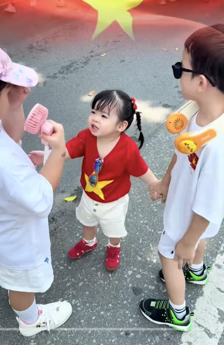 Bé TiTi mặc áo cờ đỏ sao vàng, theo bố mẹ xuống phố trong dịp sự kiện A80.