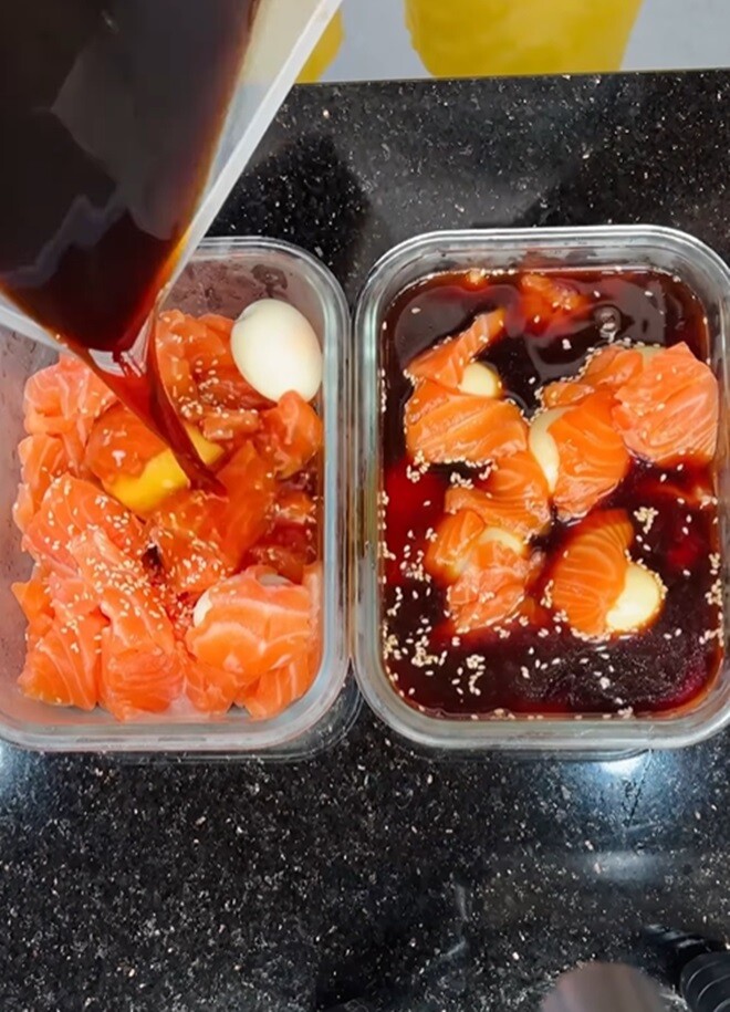 Cá hồi sau khi sơ chế được ngâm trong hỗn hợp nước tương, trứng luộc lòng đào, mè rang và tỏi ớt. Món cá hồi ngâm tương “phiên bản ba làm lần đầu” nhưng trông vô cùng hấp dẫn.