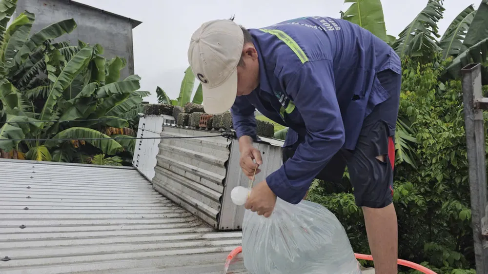 Người dân dùng các bao nước đè lên các mái tôn, ứng phó với bão số 10. ngap-lut-o-hue-19.jpg