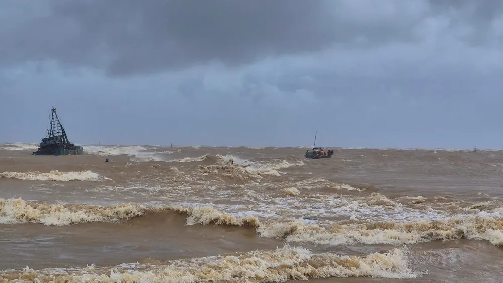 Chiếc thuyền của anh Thuận tiếp cận, ứng cứu 7 thuyền viên trên tàu mắc cạn. Ảnh: BT vu-2-tau-ca-gap-nan-ngu-dan-qua-cam-dung-thuyen-nho-vuot-song-du-cuu-7-nguoi-.jpg