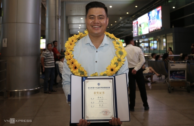 Kỳ thủ Lại Lý Huynh cùng danh hiêu vô địch cờ tướng thế giới 2025, tại sân bay Tân Sơn Nhất, TP HCM tối 28/9. Ảnh: Đức Đồng