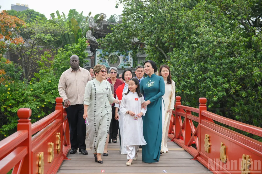 Hai Phu nhân trên cầu Thê Húc ngắm nhìn Tháp Rùa và phố phường Thủ đô. Đi cùng với hai Phu nhân còn có một bé gái gốc Việt có bố là người Việt Nam, mẹ là người Cuba. Bé được sinh ra và lớn lên tại Cuba. Ảnh: NHÂN DÂN phu-nhan-ngo-phuong-ly-tai-ngo-phu-nhan-lis-cuesta-peraza-tai-ha-noi-nhan-dan-7.jpg