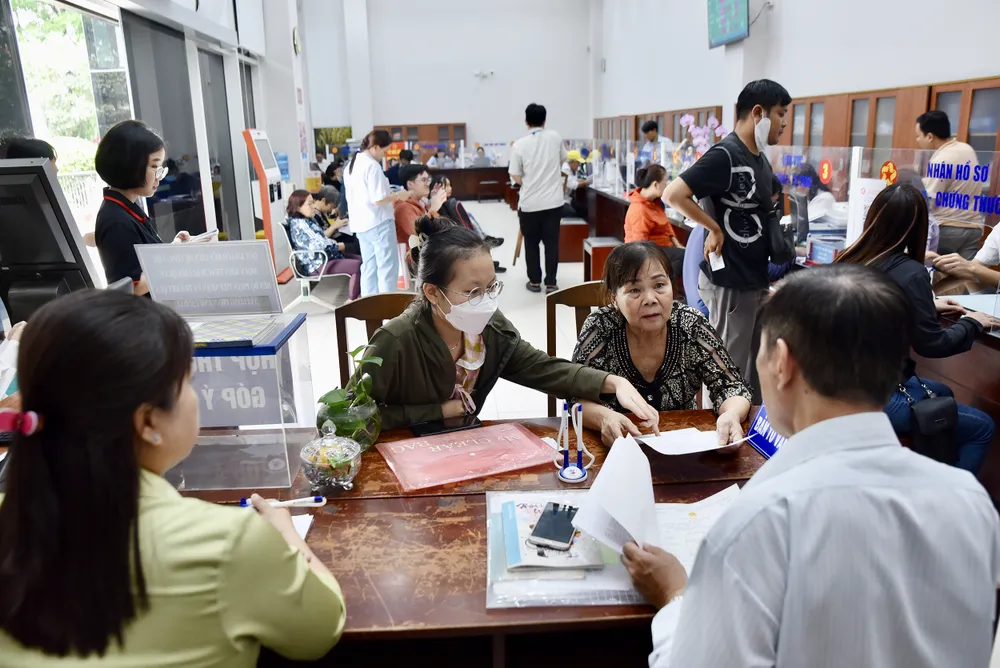 Cán bộ Trung tâm phục vụ hành chính công phường Xóm Chiếu, TP.HCM hỗ trợ người dân làm thủ tục. Ảnh: TRẦN LINH TP.HCM hướng đến công khai kết quả phục vụ của cán bộ