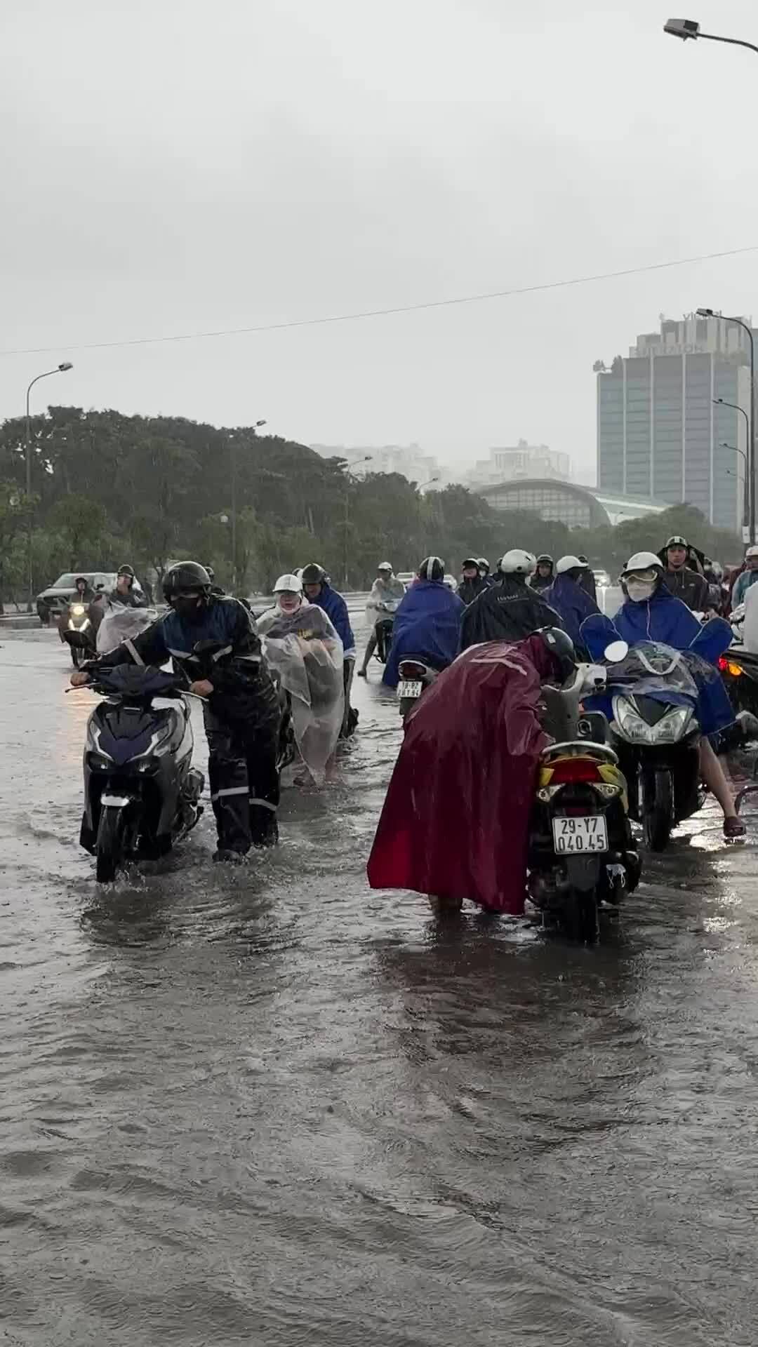 Người dân chật vật đi làm trong mưa ngập do bão