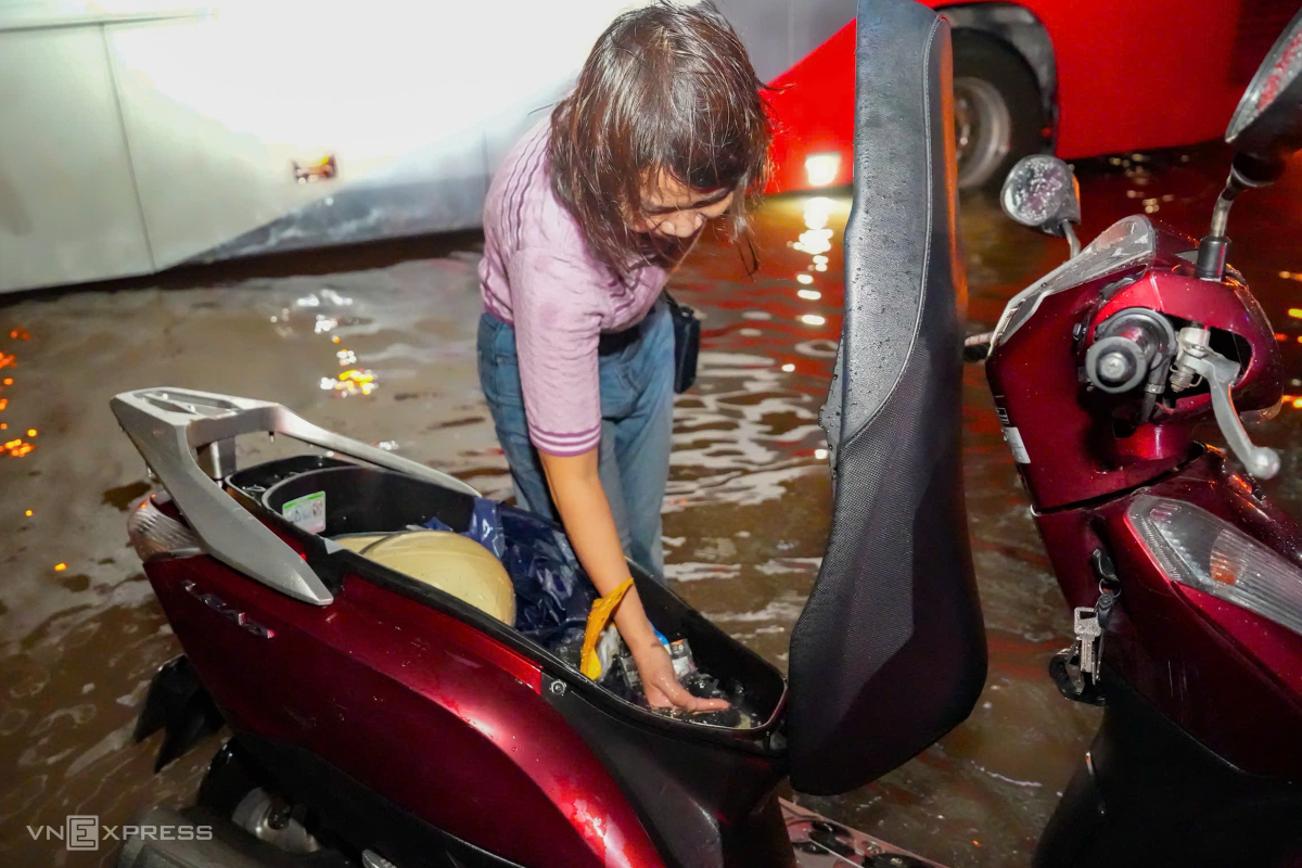 Xe máy chìm trong nước, nhiều người phải tát nước khỏi cốp xe để dắt về nơi sửa. Ảnh: Tùng Đinh
