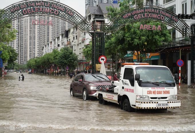 Xe cứu hộ giao thông kéo ôtô qua đoạn ngập khu vực An Khánh, Hoài Đức, Hà Nội, ngày 30/9. Ảnh: Hoàng Giang