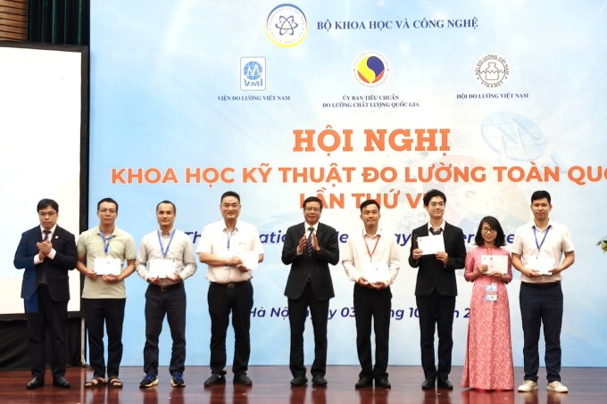 Thứ trưởng Lê Quang Định và Chủ tịch Ủy ban Tiêu chuẩn Đo lường Chất lượng Việt Nam Nguyễn Nam Hải trao kỷ niệm chương và quà cho một số nhà khoa học có báo cáo được vinh danh. Ảnh: Trọng Đạt