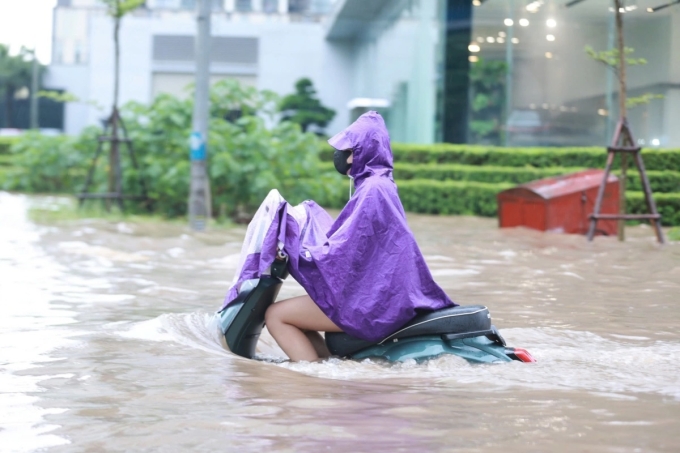Xe máy lao qua vùng ngập nước ở Hà Nội, ngày 26/8. Ảnh: Đức Đồng