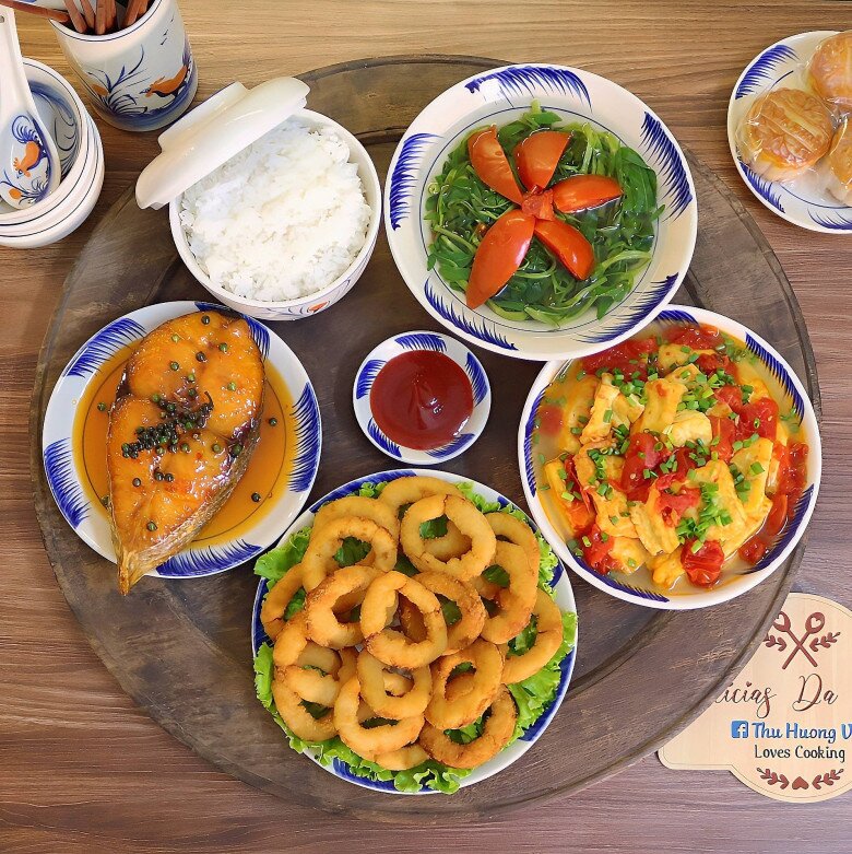 Mâm cơm này gồm các món: Mực chiên, cá thu sốt cam, đậu sốt cà chua, canh rau muống.