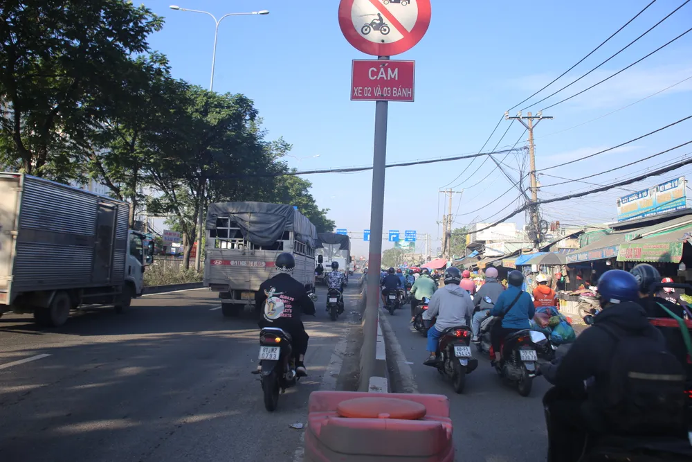 Trước cổng chợ đầu mối Thủ Đức: Làn xe ô tô thành "lối tắt" cho xe máy. Ảnh: PHẠM HẢI Trước cổng chợ đầu mối Thủ Đức: Làn xe ô tô thành "lối tắt" cho xe máy. Ảnh: PHẠM HẢI