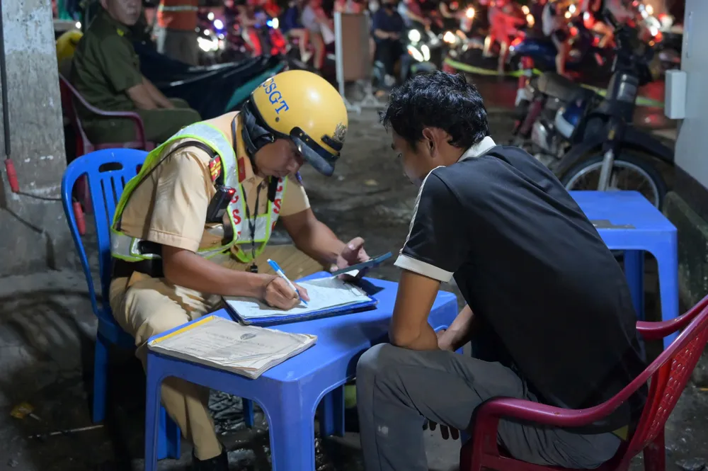 Tài xế BKU bị CSGT lập biên bản vi phạm hành chính và tạm giữ phương tiện theo quy định. Ảnh: PHẠM HẢI uong-bia-mung-20-10-tai-xe-bi-xu-phat-9-trieu-dong-vi-vi-pham-nong-do-con_11.jpg