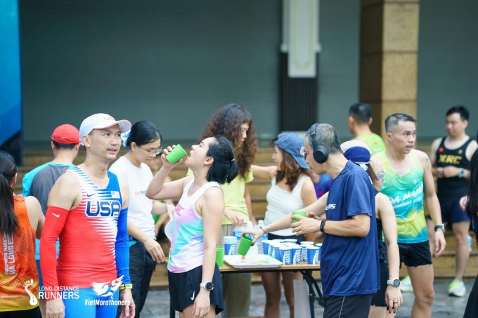 Runner ghé trạm nước bổ sung nước điện giải trong buổi chạy dài tại hồ Hoàn Kiếm, Hà Nội. Ảnh: Long Distance Runners