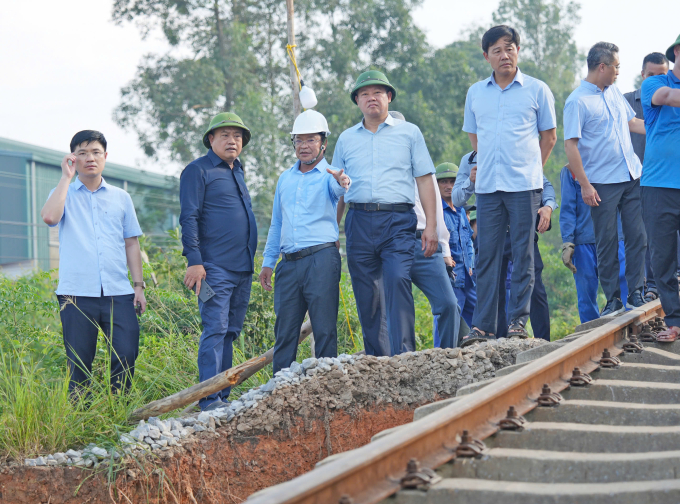 Chủ tịch Hà Nội Trần Sỹ Thanh (thứ 2 từ trái qua) thị sát vị trí nền đường sắt bị cuốn trôi trơ lại đường ray. Ảnh: Võ Hải