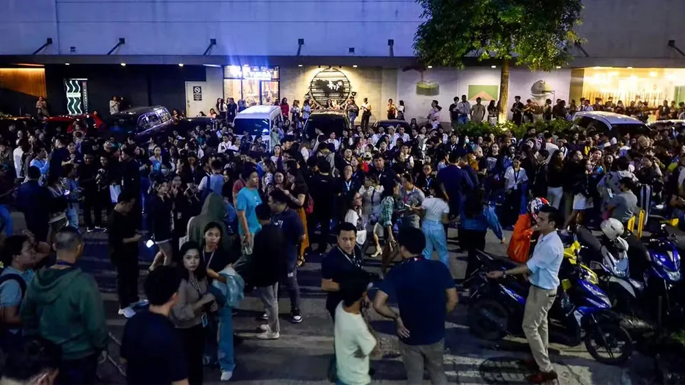 Người dân tập trung bên ngoài tòa nhà văn phòng sau trận động đất 6,9 độ richter ở Cebu tối 30-9. Ảnh: AFP động đất ở philippines