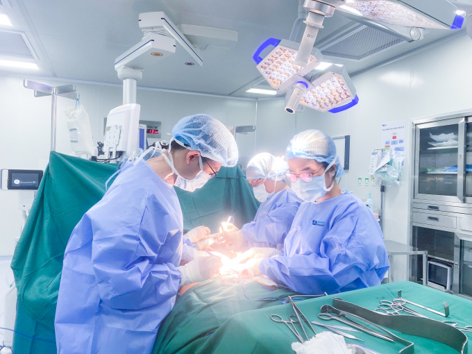 Bác sĩ Tấn (trái) cùng êkíp phẫu thuật điều trị ung thư vú cho chị Thanh. Ảnh: Bệnh viện cung cấp