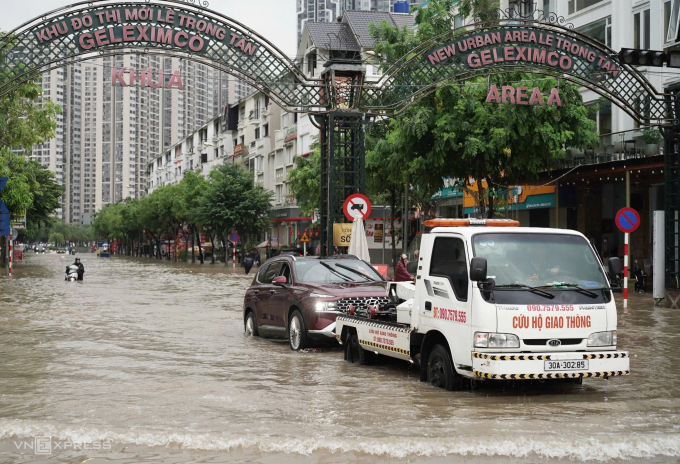 Xe cứu hộ giao thông kéo ôtô qua đoạn ngập khu vực An Khánh, Hoài Đức. Ảnh: Hoàng Giang