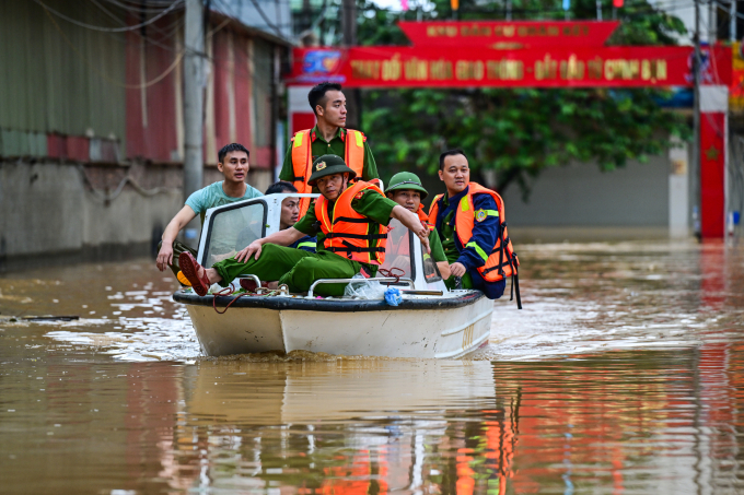 Dùng thuyền cứu hộ tiếp tế cho người dân vùng ngập lụt ở tỉnh Lào Cai. Ảnh: Giang Huy