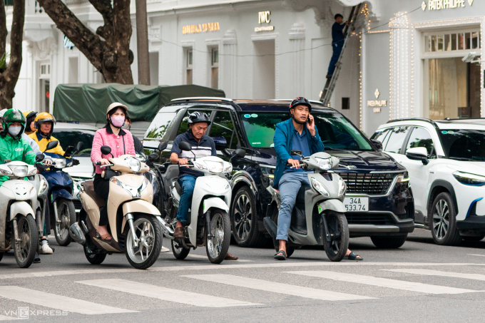 Các tài xế sử dụng điện thoại khi dừng đèn đỏ tại Hà Nội. Ảnh: Minh Quân