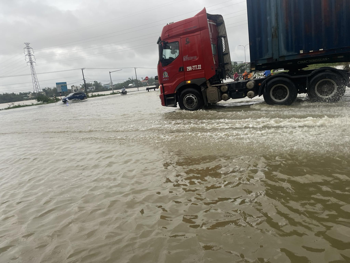 Nước lũ băng qua Quốc lộ 1 ở Đà Nẵng, CSGT cấm đường, phân luồng lên cao tốc - Ảnh 1.