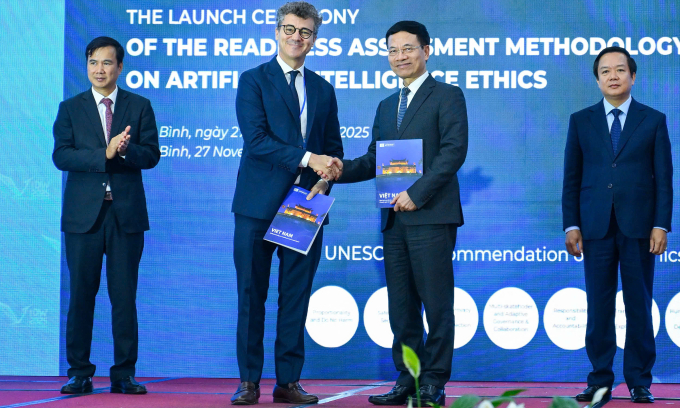 Bộ trưởng Nguyễn Mạnh Hùng (bìa phải) nhận bàn giao biểu trưng báo cáo RAM từ ôngJohnathan Bake, Trưởng văn phòng và đại diện UNESCO tại Việt Nam.Ảnh:Giang Huy