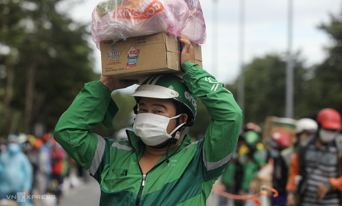 Shipper đứng xếp hàng chờ giao đồ trước bệnh viện dã chiến số 6, thời điểm dịch Covid-19. Ảnh: Thành Nguyễn