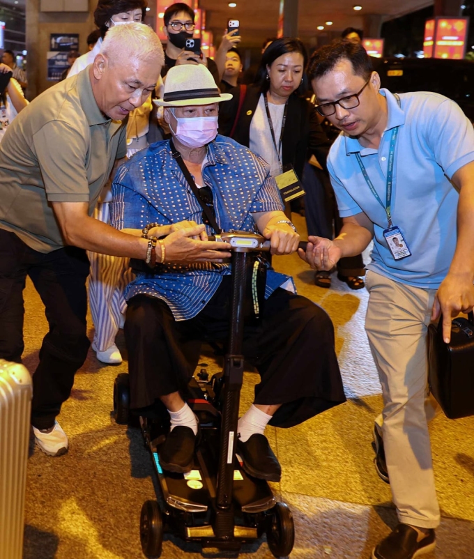 Nghệ sĩ Hồng Kim Bảo di chuyển bằng xe điện mini ở sân bay, tối 5/11. Ảnh: Quỳnh Trần