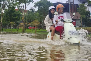 Mưa lớn dồn dập, lũ dâng cao, người dân Huế vội vã đưa xe đi tránh lũ