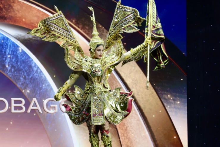 Trang phục dân tộc đa sắc màu của thí sinh Miss Universe 7 Bộ trang phục của Veena Praveenar Singh - Miss Universe Thailand 2025 - lấy cảm hứng từ hình tượng Người hộ vệ khổng lồ trong văn hóa dân gian Thái Lan. Theo World Beauties, trang phục chế tác với sắc vàng chủ đạo nhằm gợi nhắc sự phong phú của di sản và nghệ thuật truyền thống, nhận về 23 nghìn lượt thích.