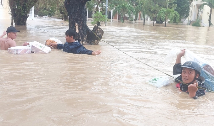 Các thầy bơi, bám theo đường dây để chuyển nhu yếu phẩm vào cho sinh viên trong ký túc xá, ngày 19/11. Ảnh: Nhà trường cung cấp