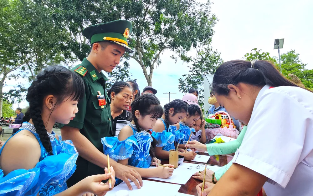 Các em học sinh say mê học viết chữ thư pháp. đồng hành với học sinh biên giới 1.jpg
