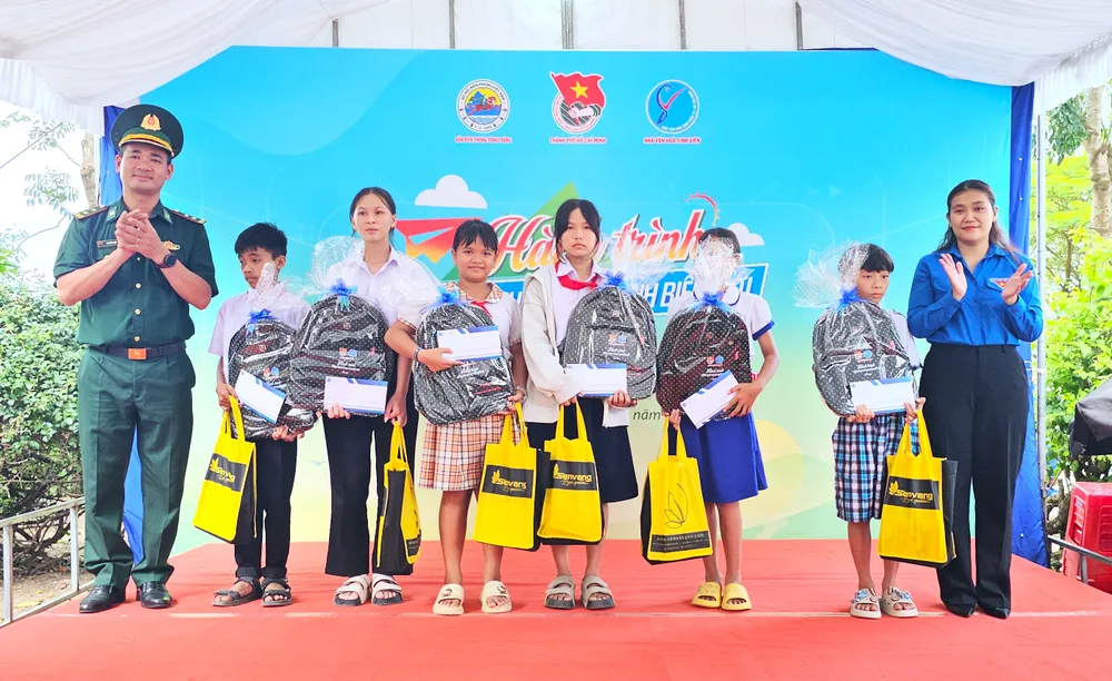 Trung tá Bùi Ngọc Thiệp, Chính trị viên Đồn Biên phòng Sông Trăng (xã Hưng Điền, Tây Ninh) cùng chị Huỳnh Bùi Huỳnh Kiều My, Phó Giám đốc Nhà văn hóa sinh viên TP.HCM trao tặng quà cho các em học sinh. đồng hành với học sinh biên giới 8.jpg