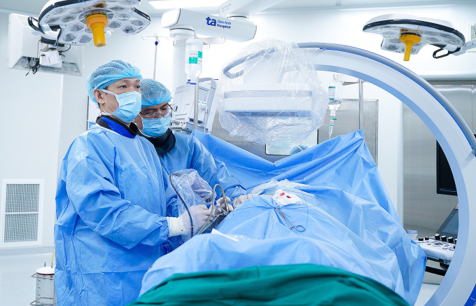 Bác sĩ Cương (trái) tán sỏi thận qua da cho bà Trinh. Ảnh: Bệnh viện Đa khoa Tâm Anh