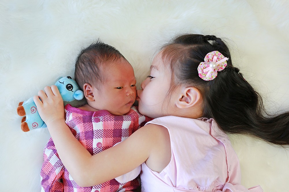 Việc tiếp xúc gần, âu yếm, hôn má trẻ từ trẻ lớn, người lớn trong gia đình có thể lây virus RSV cho trẻ. Ảnh: Shutterstock